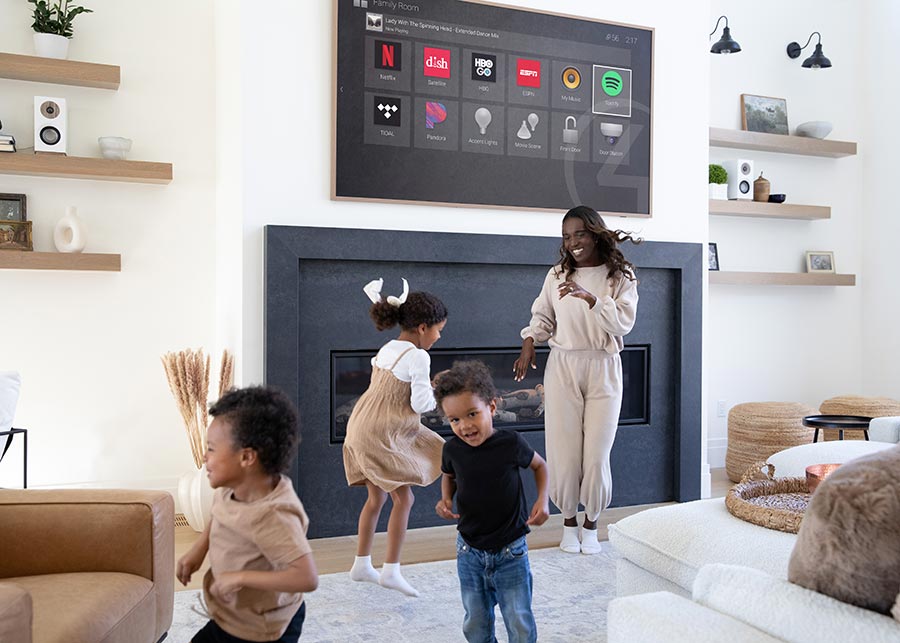 Family with kids playing in smart living room with TV on fireplace