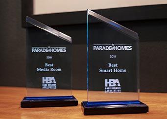 Two glass awards labeled Best Media Room and Best Smart Home