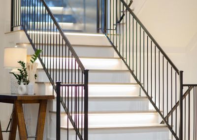 Interior staircase with modern black railing and step lights